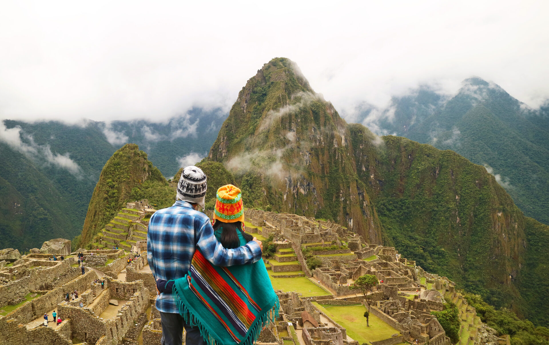 Couple being impressed with the incredible view of Machu Picchu ancient Inca citadel, UNESCO world heritage site in Cusco Region, Peru, South America